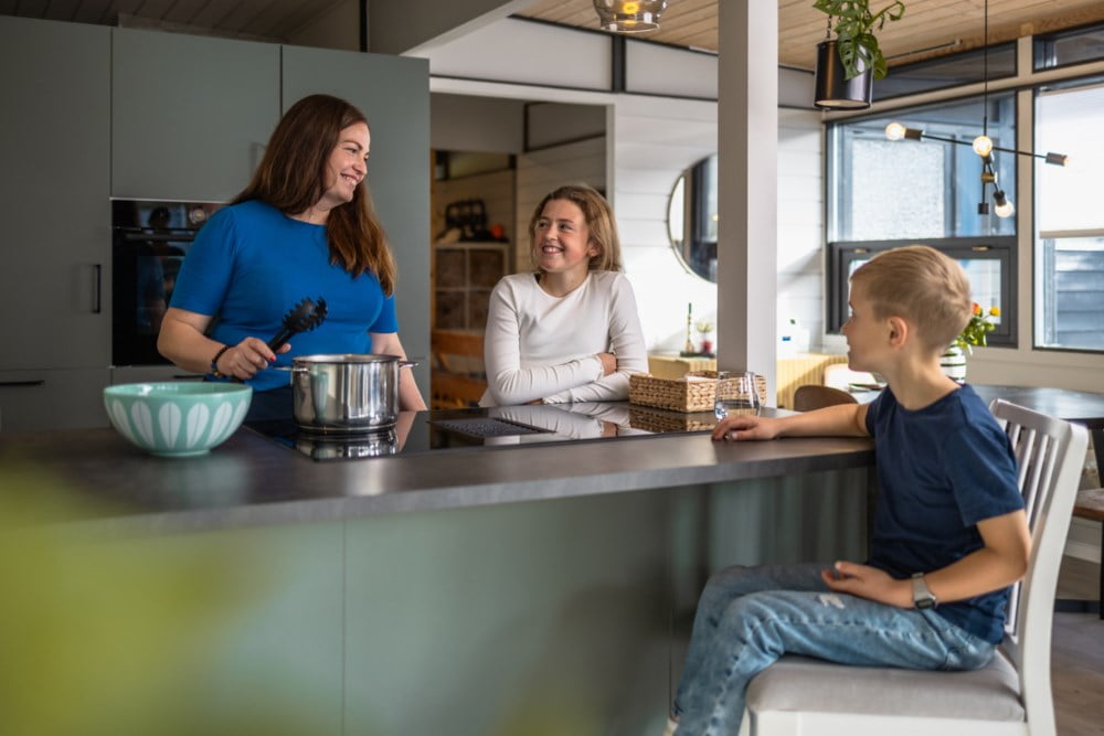 Kvinne og to barn lager middag