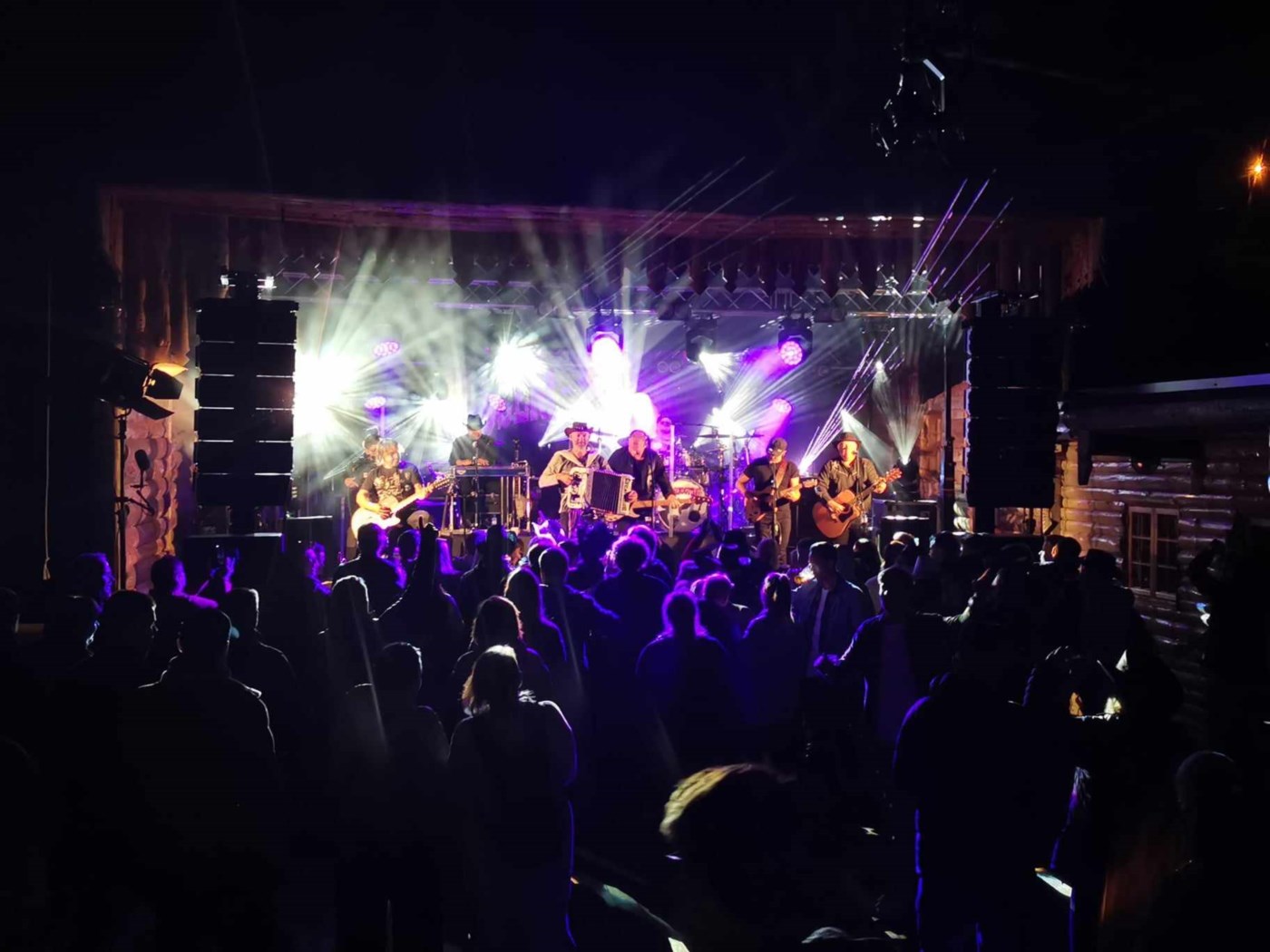 Bandet Vassendgutane spiller på scenen med sort publikum som tilskuere.