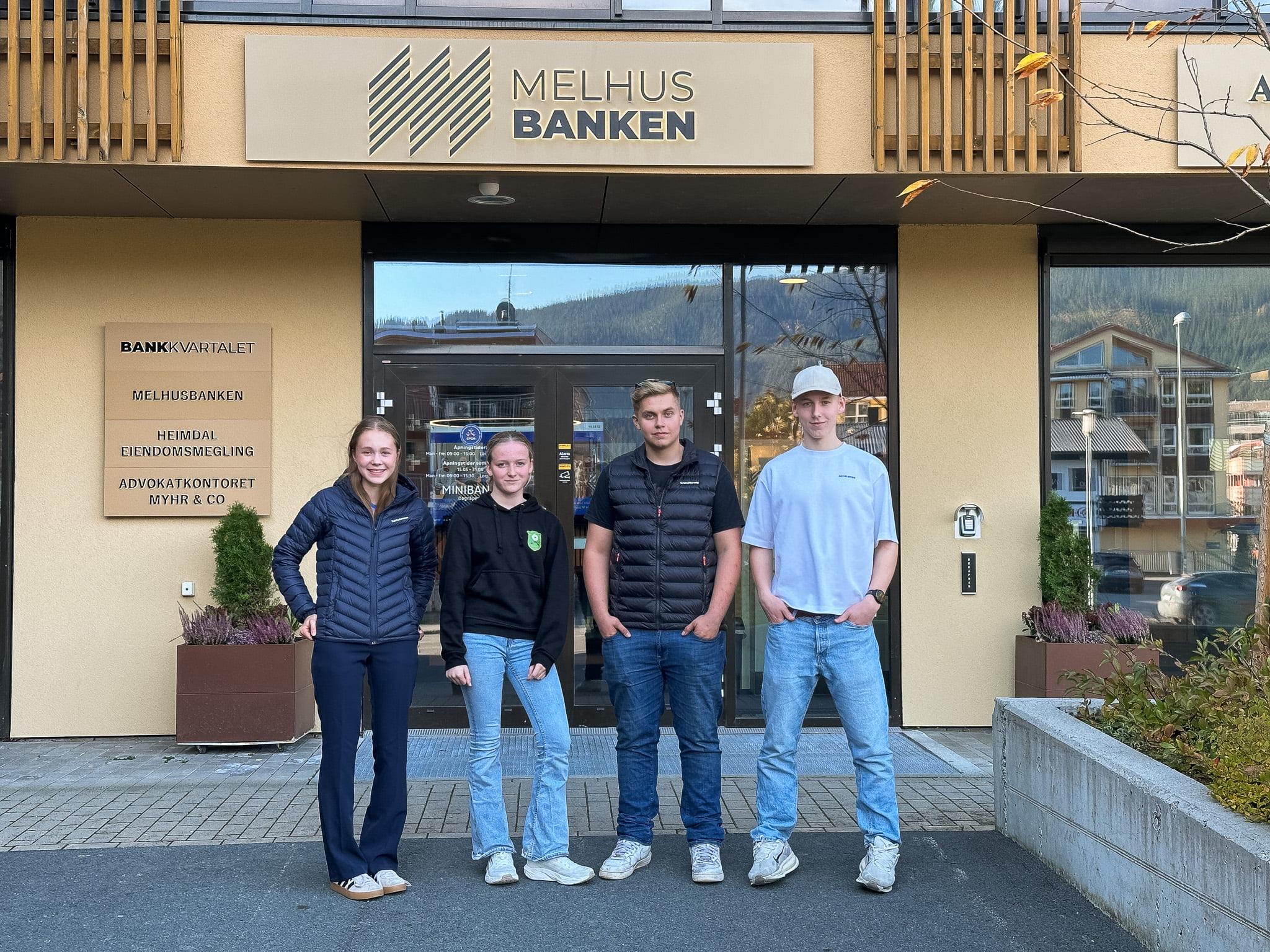 Fire unge mennesker utenfor et kontorlokale. Talentstipend-mottakerne utenfor MelhusBanken.