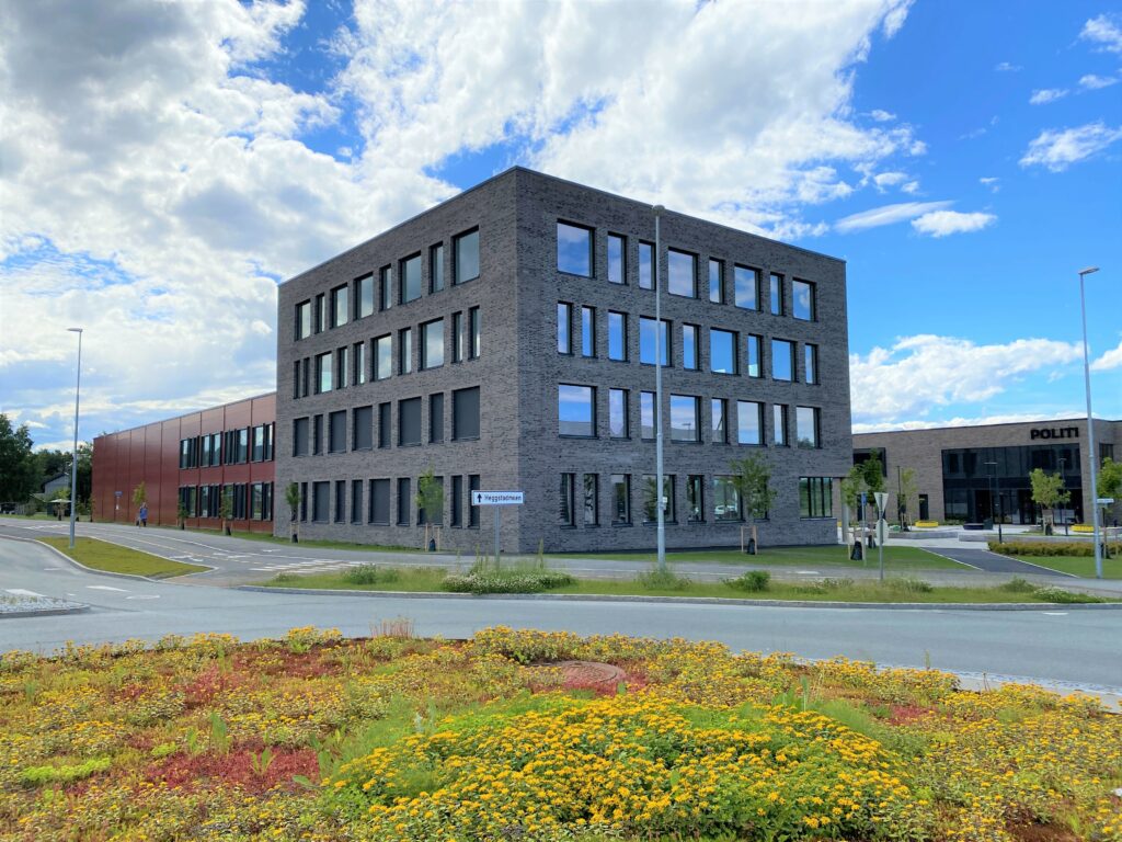 Kontorlokalet på Heimdal sett fra veien. Murbygg i naturfarge med grøntareal rundt. 