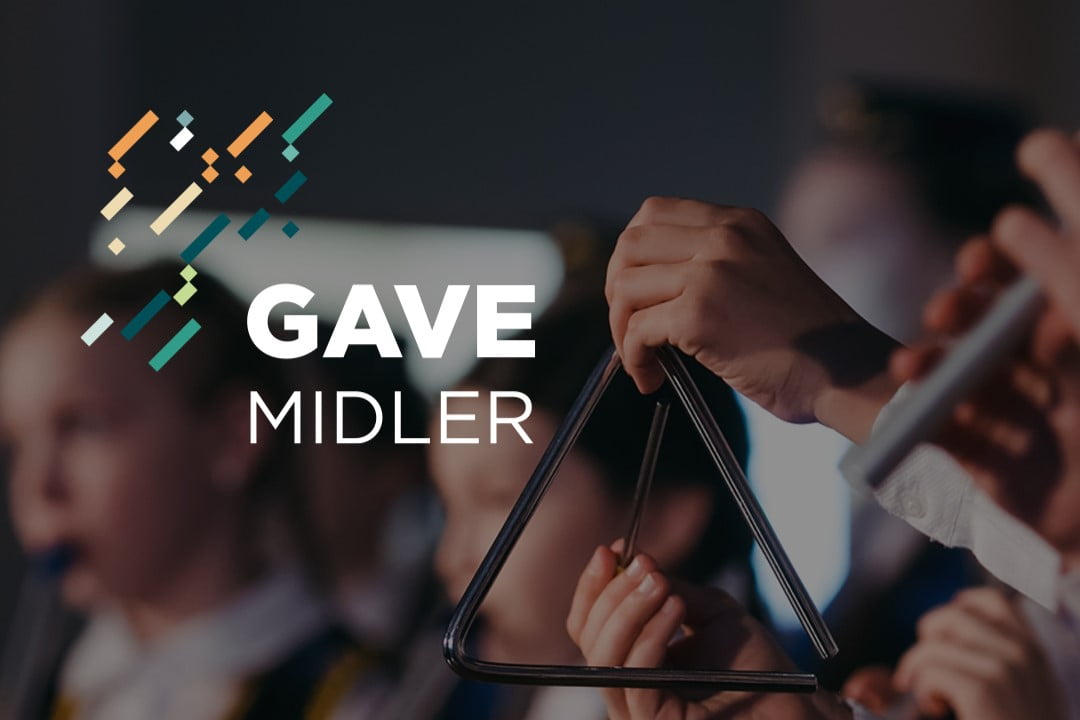 Nærbilde med lav dybdeskarphet av barnekorps. Hender som spiller på et triangel. "Gavemidler"